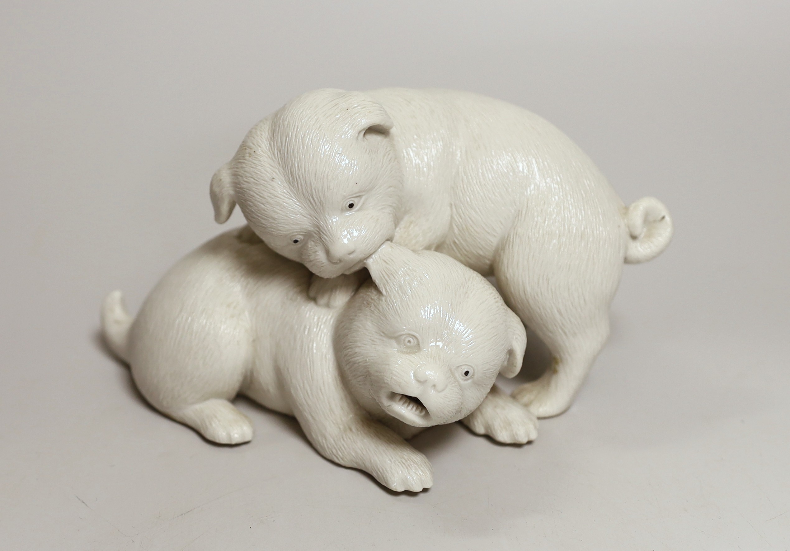 A Japanese Hirado white glazed model of two pugs, Meiji period, 17cm